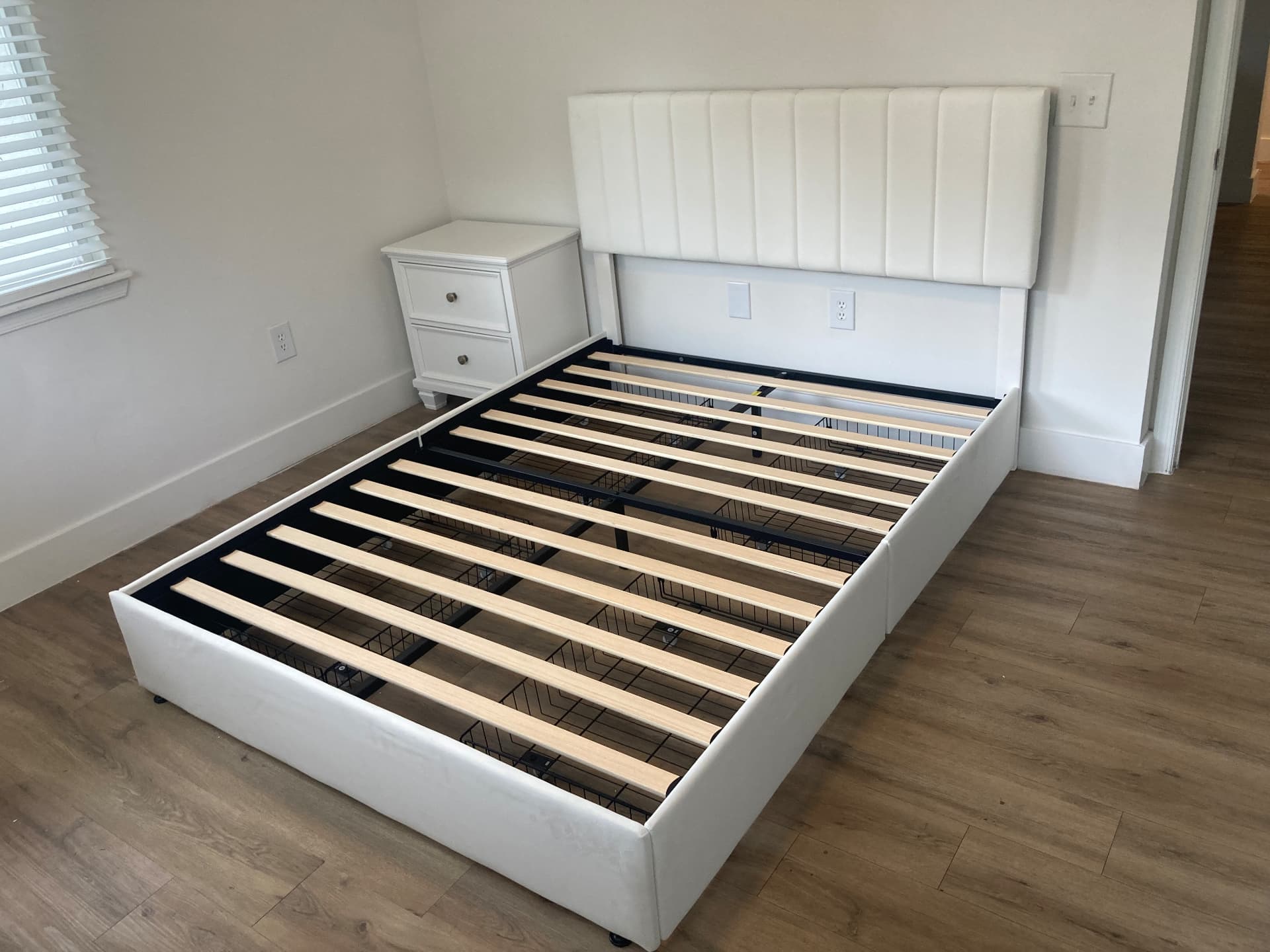White upholstered channel headboard platform bed frame assembled in a Jupiter bedroom